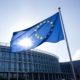 Drapeau européen flottant devant un bâtiment des institutions européennes