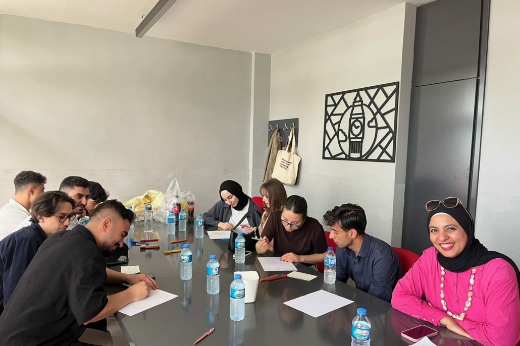 Une animatrice discute avec trois jeunes lors de l'atelier OUR CULTURE à Paris