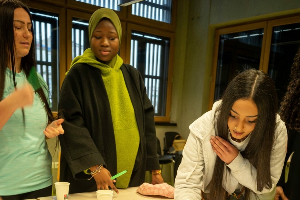 Une participante écrit sur l'affiche « Culture » couverte de mots lors de l'atelier OUR CULTURE en France